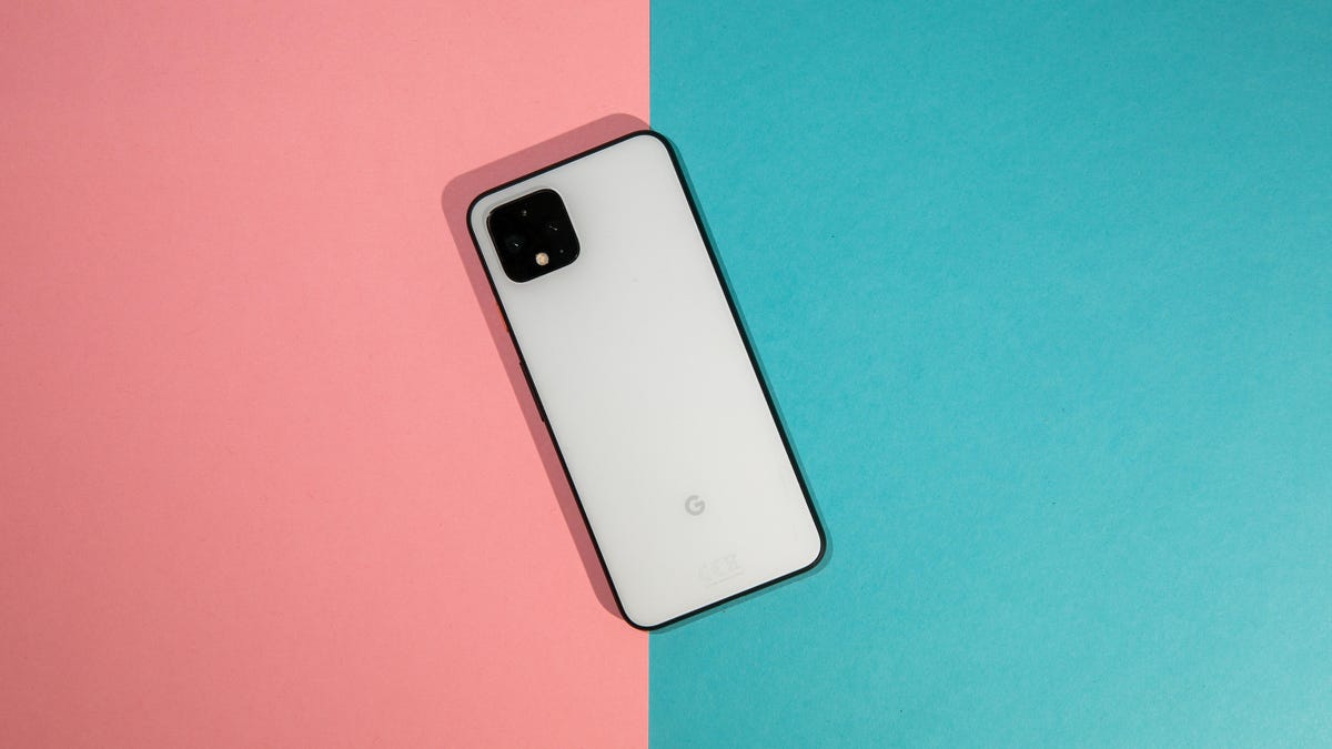 A white Pixel 4 face down on a pink and turquoise background.