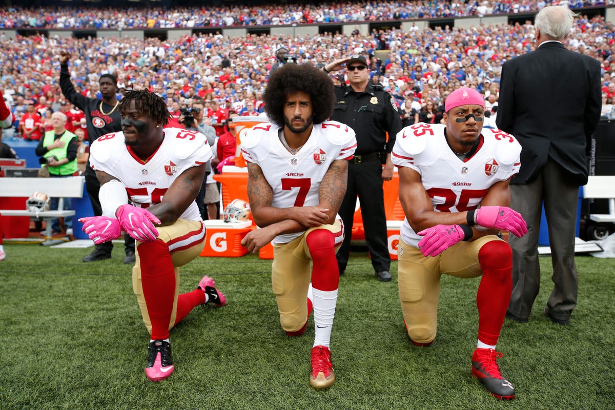 Colin Kaepernick (center) said his original protests during the national anthem, like this one before a game in October 2016, were meant to draw attention to police misconduct.