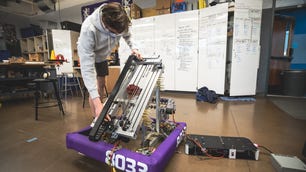 As evidenced by the whiteboard behind team member Caetano de Figueiredo, as he adjusts the drive train for the telescopic boom on the team's robot, many hours of meticulous planning go into building a competition-ready robot.
