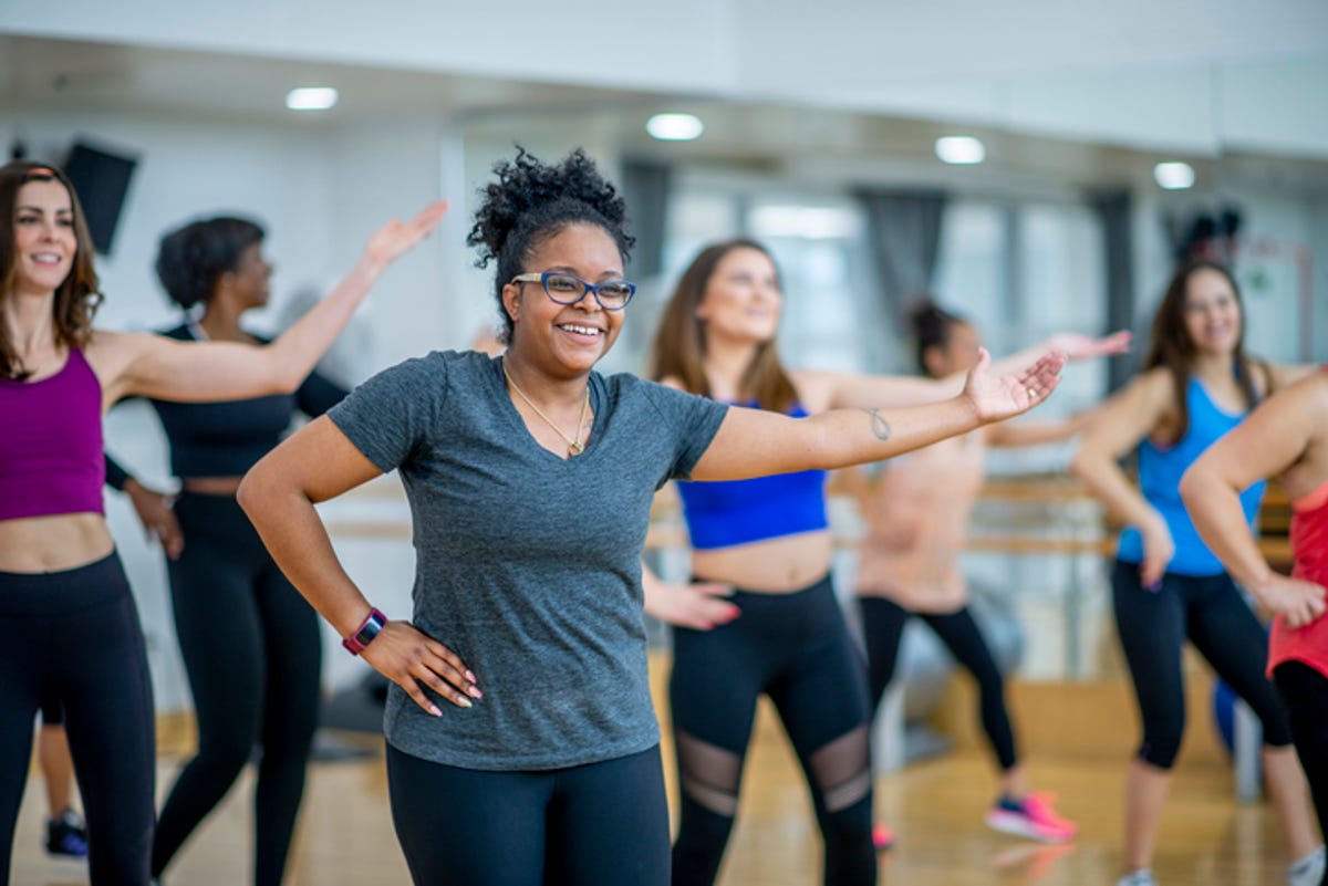 Young women in fitness dance class performing moves