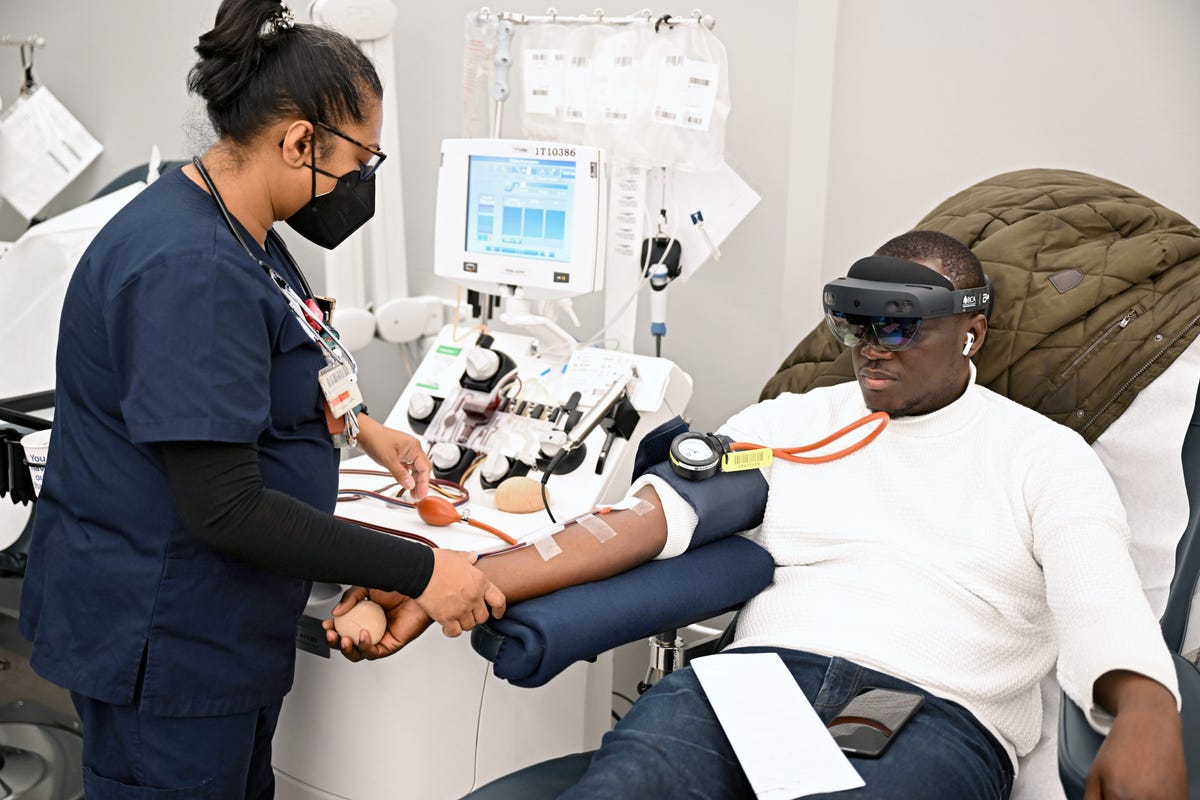 A patient donates blood while wearing a mixed reality headset.