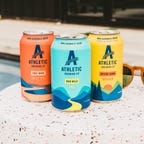 athletic brewing cans by the pool