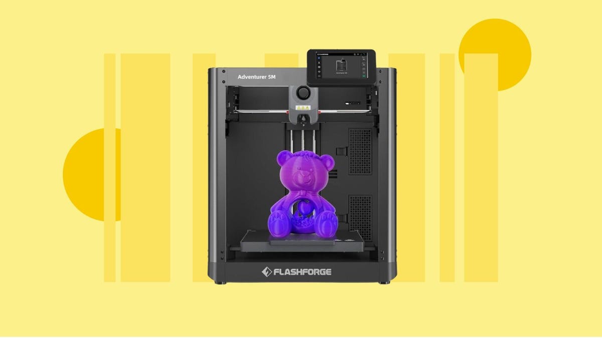 A black 3D printer with a printed bear inside on a yellow background