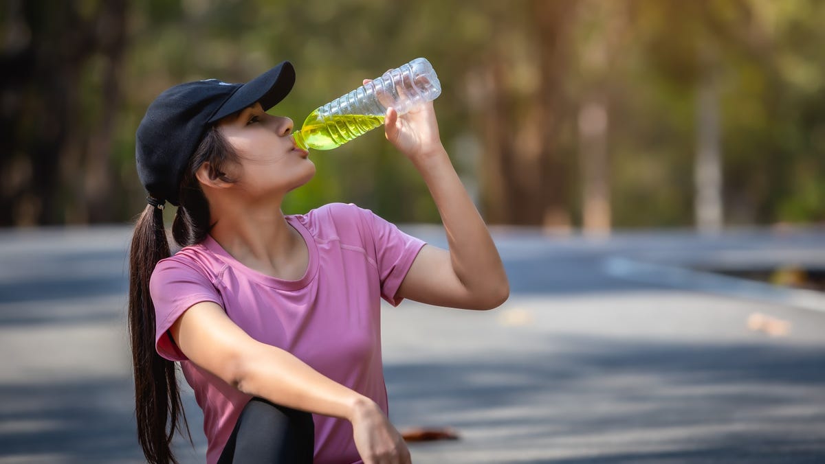 Woman drinking electrolyte beverage after workout