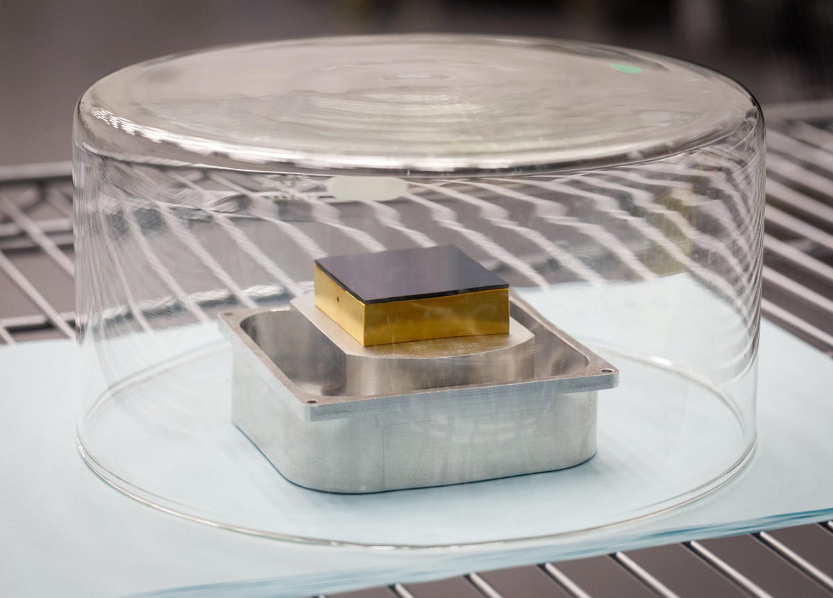 A single 16-megapixel image sensor, one of 189 that SLAC will use to build a telescope called the LSST, rests under glass and in a clean room to avoid contamination.