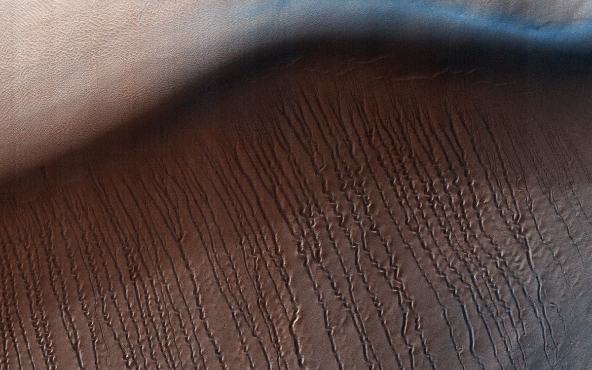 What does this look like to you? Claw marks? Eyelashes? This is a look at a series of squiggly lines captured by NASA's Mars Reconnaissance Orbiter in 2017. The space agency says the linear gullies are likely caused by dry ice sliding down sandy dune slopes.
