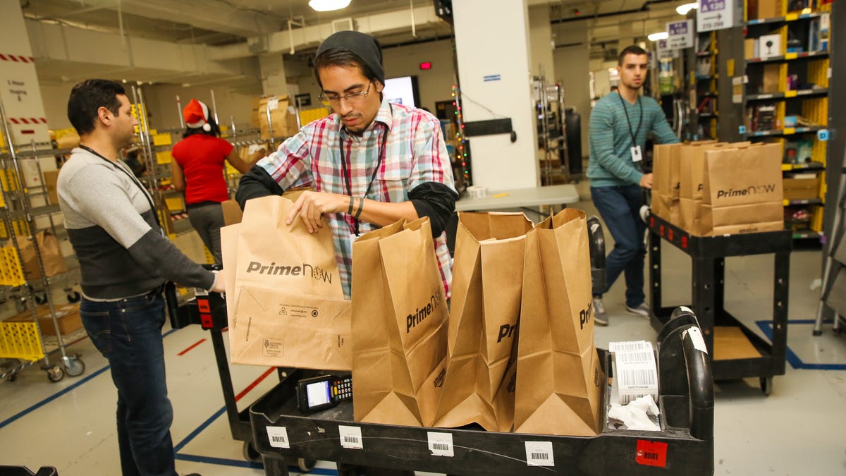 Workers prep Prime Now deliveries in an Amazon warehouse.