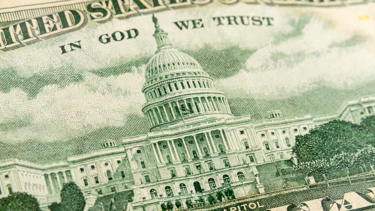 A close-up of the back of a fifty dollar bill, showing the engraving of the US Capitol building.