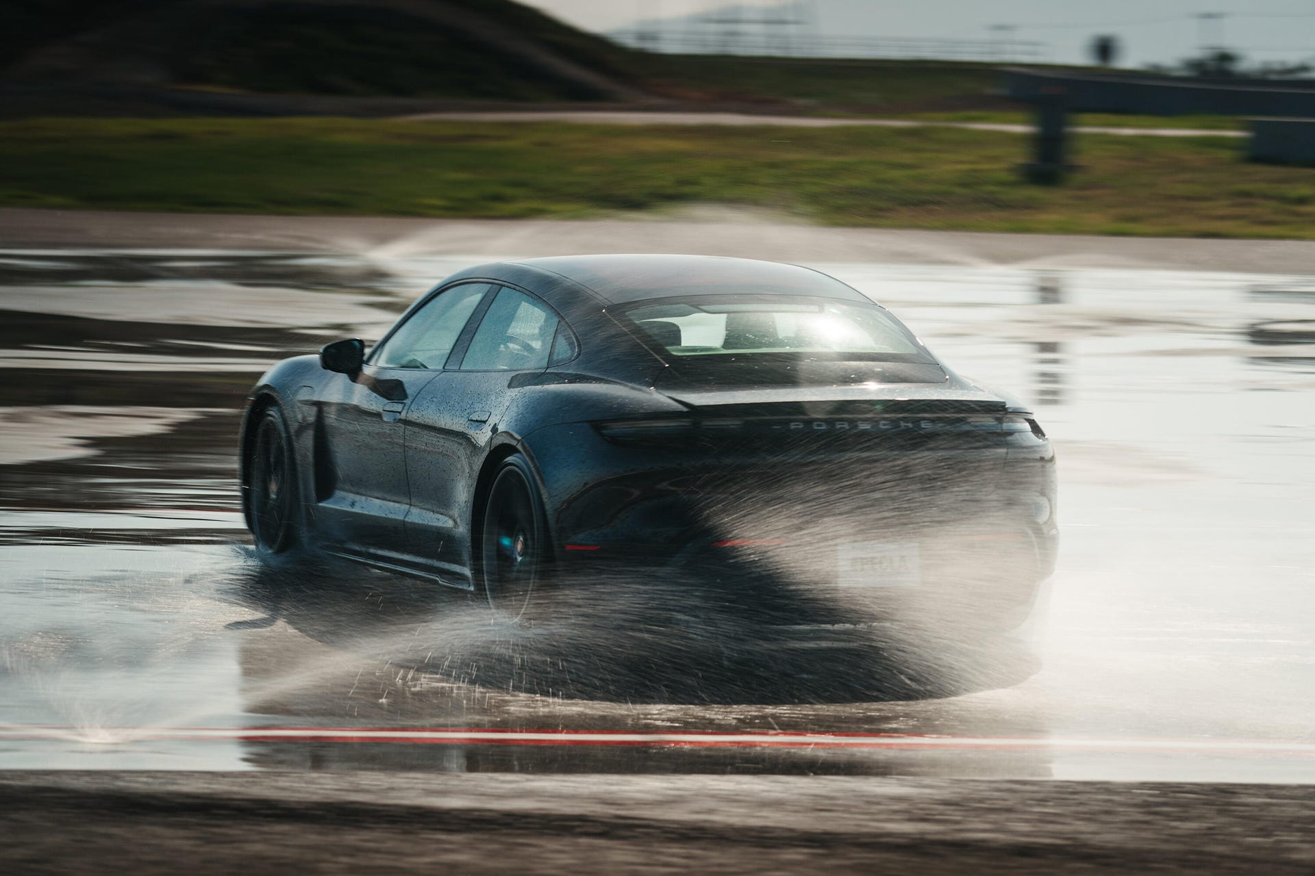 Taycan Turbo drifting in the wet at the Porsche Experience Center