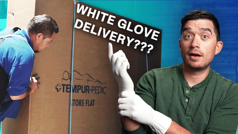 A man moving a mattress in a box against a colorful background with a man in the front wearing white gloves.