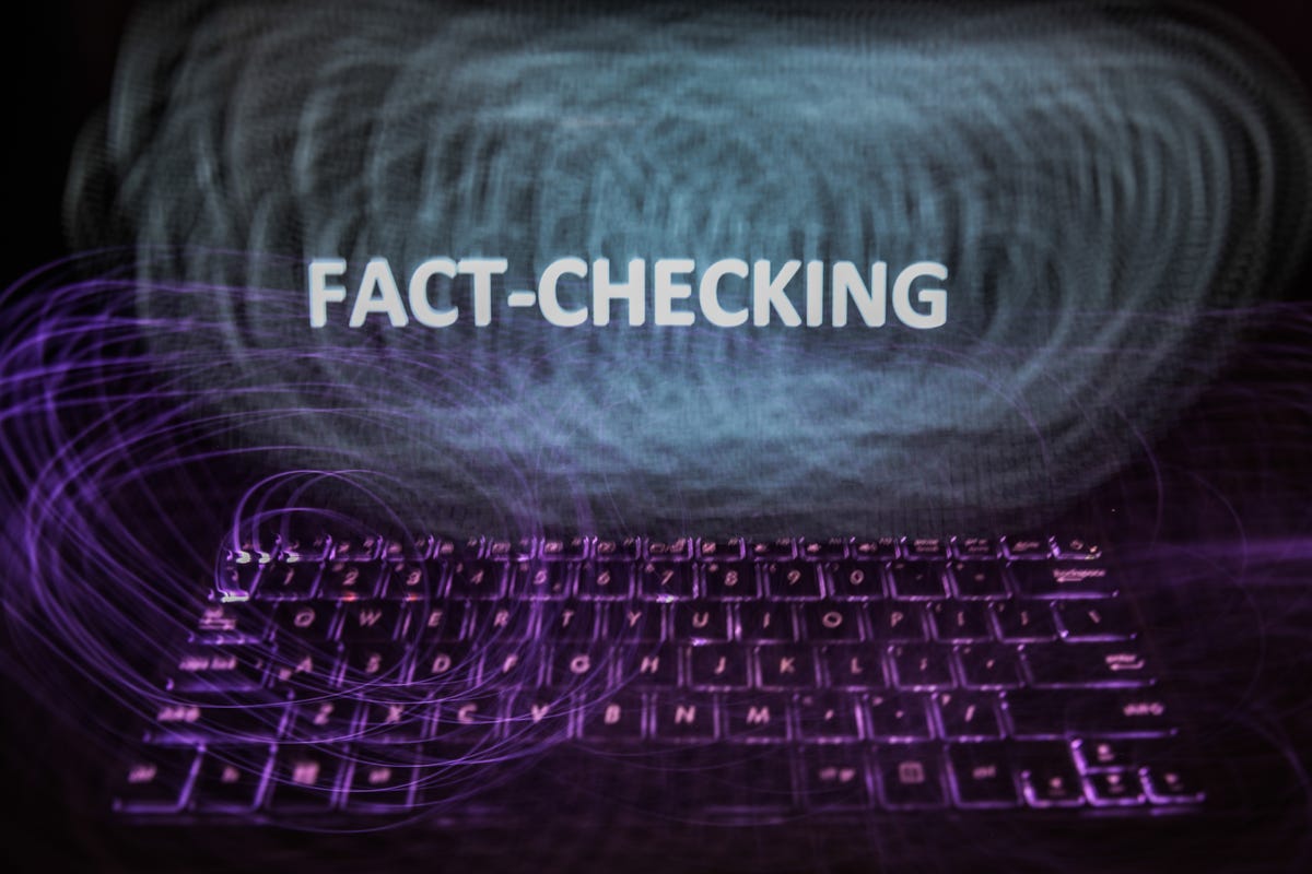 "Fact-checking" sign is seen displayed on a laptop screen in this long exposure photo-illustration.