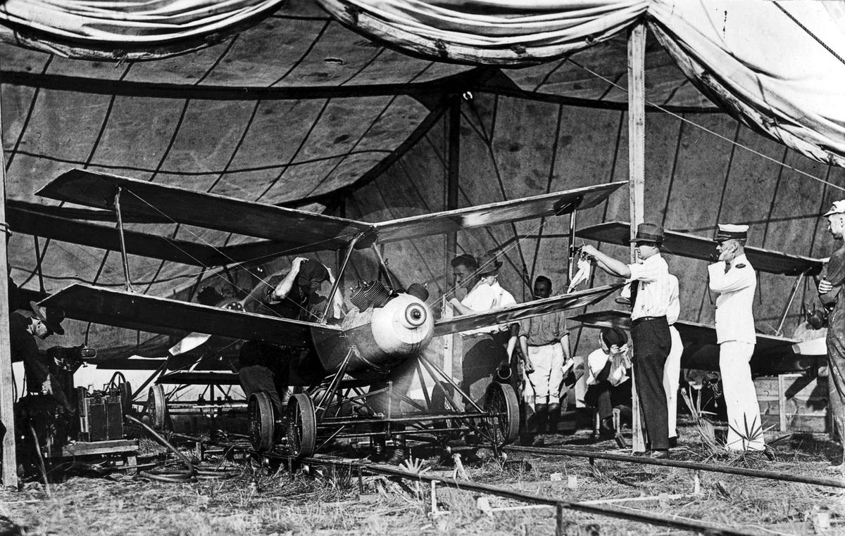 Kettering Aerial Torpedo under a tent and on rails, with men gathered around