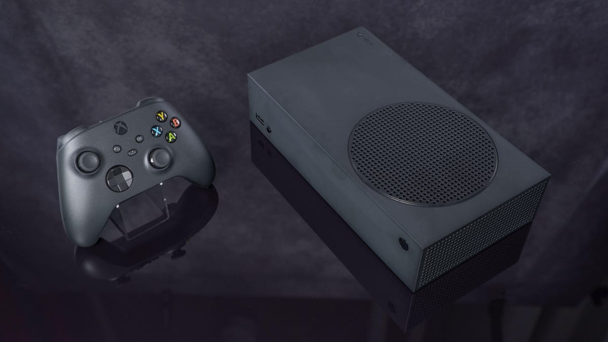 an xbox series s in black next to a black controller