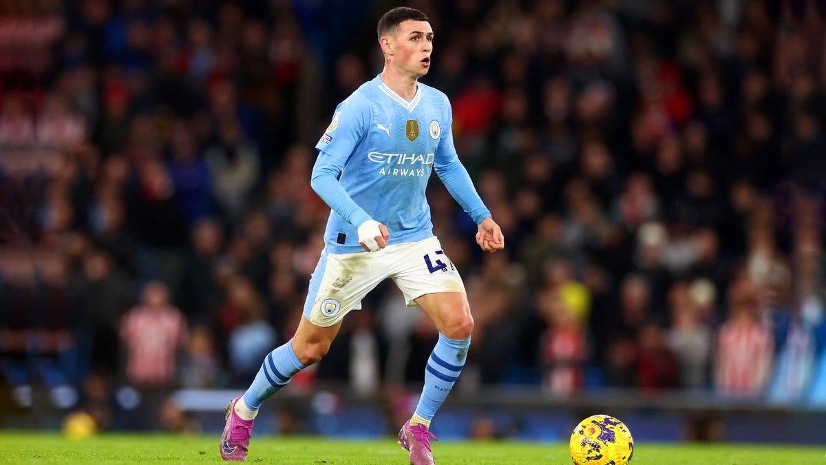 Manchester City forward Phil Foden running with the ball at his feet.