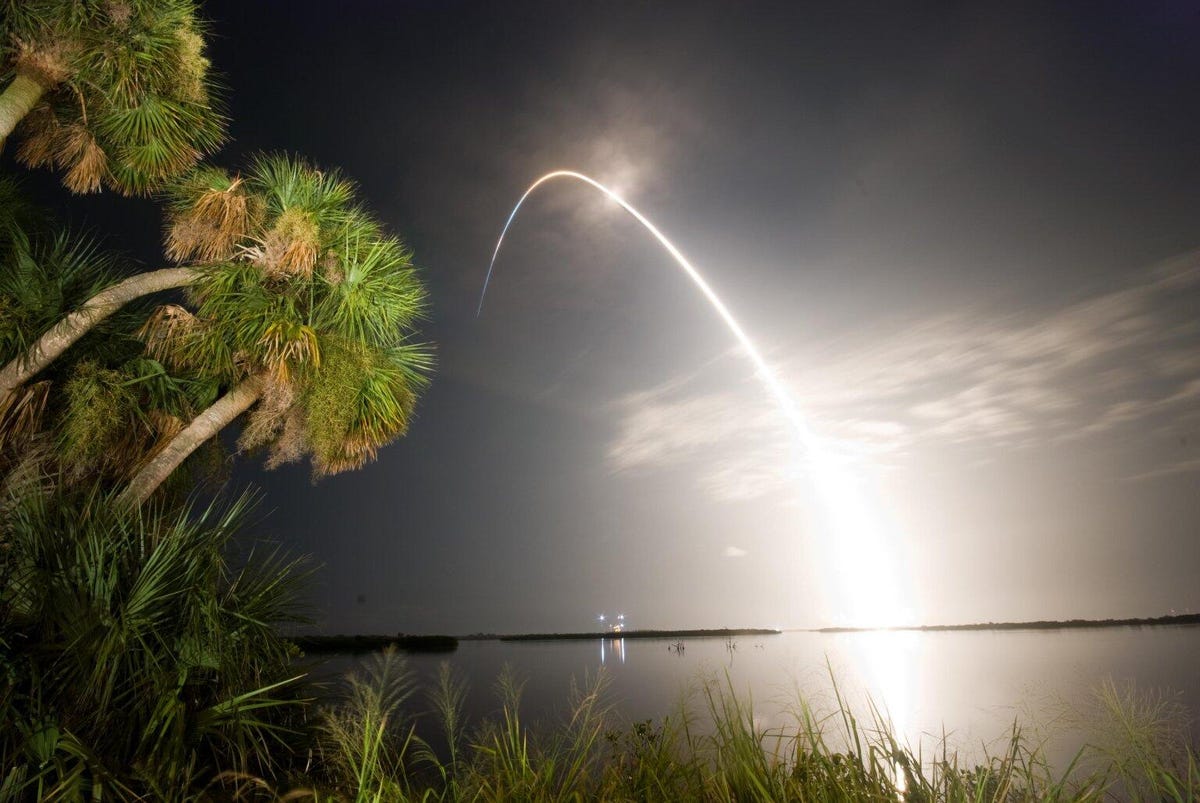 A 2009 launch of NASA's Space Shuttle Discovery shows the arcing path of a spacecraft headed to orbit. It's harder to get the lateral speed needed to stay in orbit than it is to get up to space, so rocket engines propel the spacecraft over the horizon.