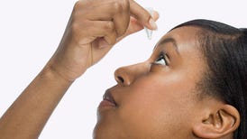 woman applying eye drops