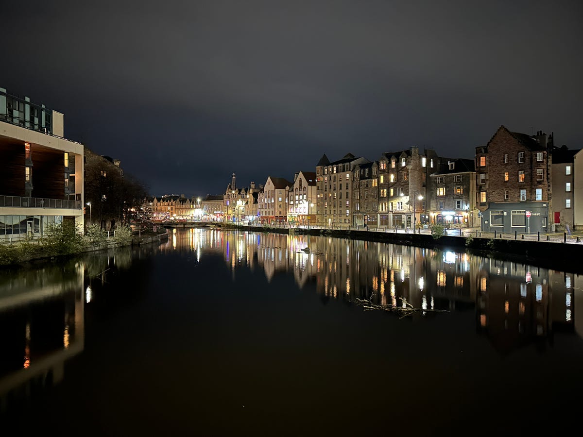 A row of buildings along a river at night