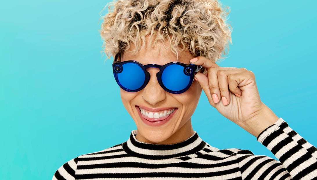 A woman wears a pair of new black Spectacles with blue lenses.