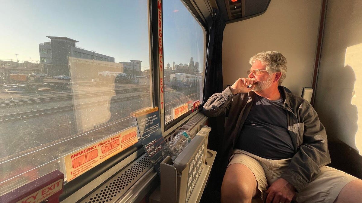 The reporter's dad sitting pensive and tired, bathed in the amber light of early evening, staring out the window as the Seattle skyline looms in the distance.
