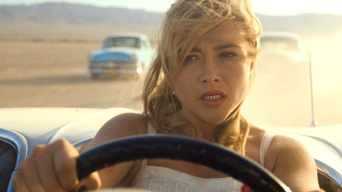 Florence Pugh drives across a desert in the movie Don't Worry Darling.