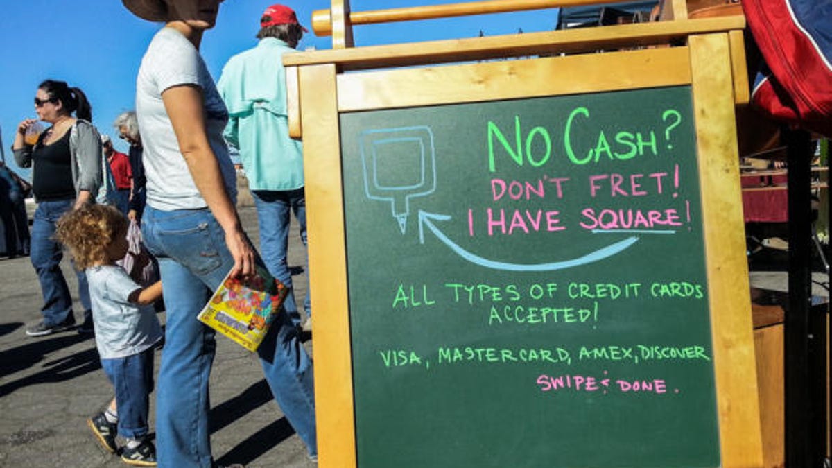 A merchant accepting Square's mobile payments lets potential buyers know that at an antiques fair in Alameda, Calif.