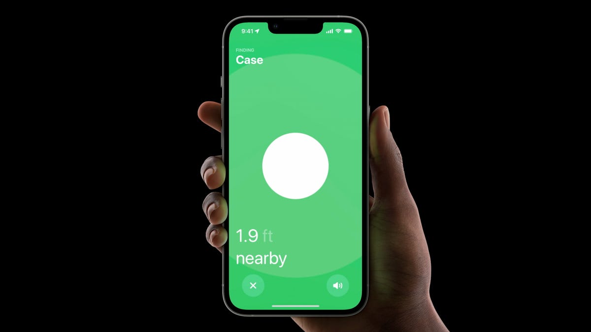 A hand holding an iPhone with the Find My app open