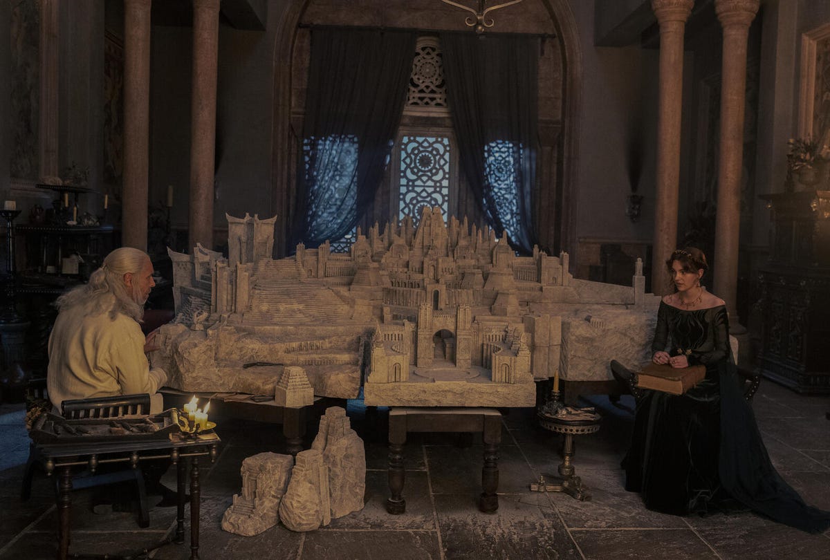 Viserys and Alisont Hightower sit at opposite ends of a clay model of King's Landing