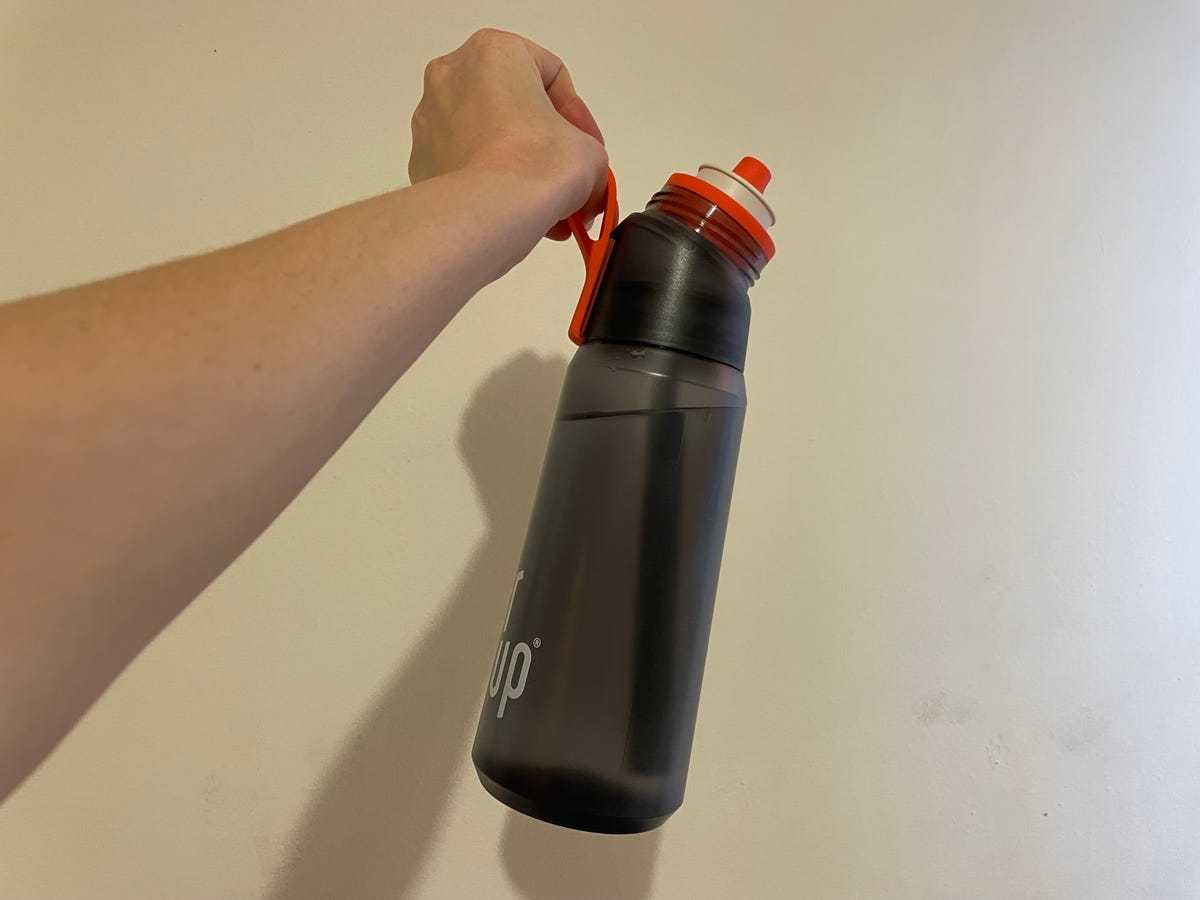 Uma mão segurando uma garrafa de água Air Up 