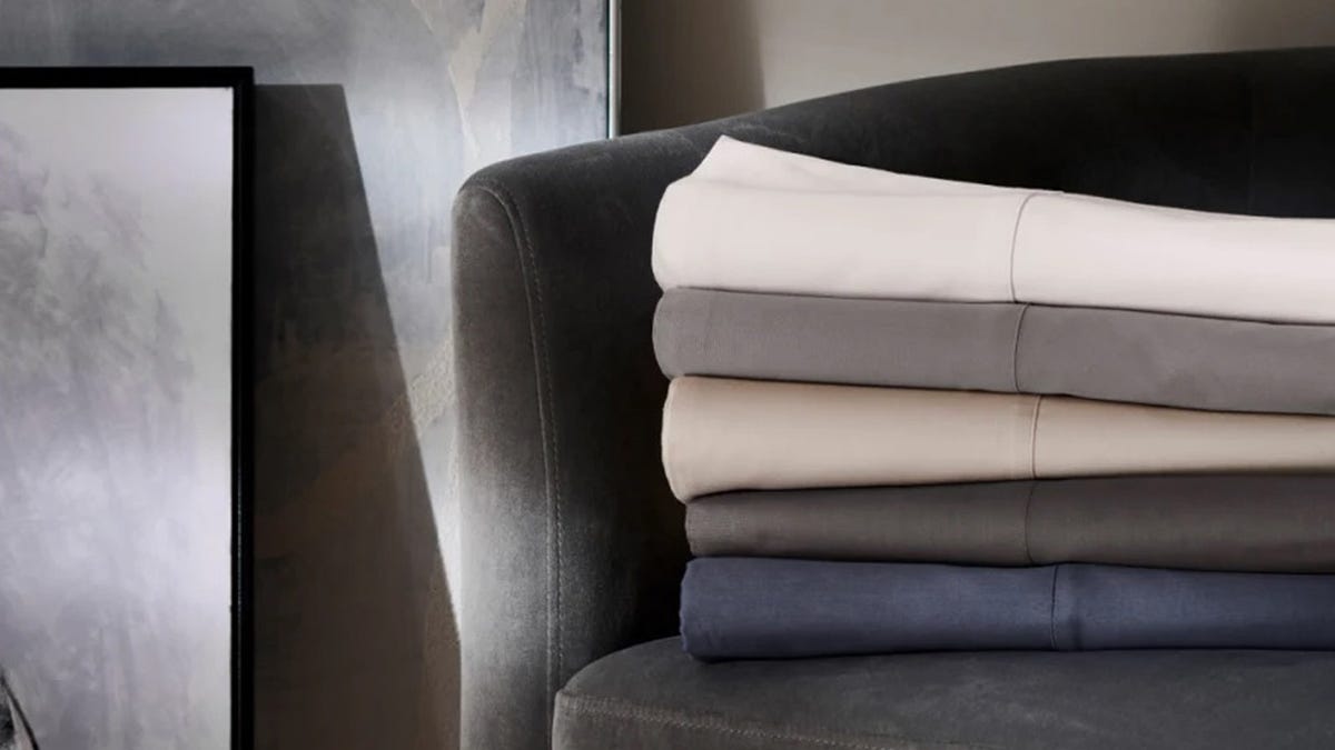 Sheets from Boll & Branch in various colors sit folded on a chair.
