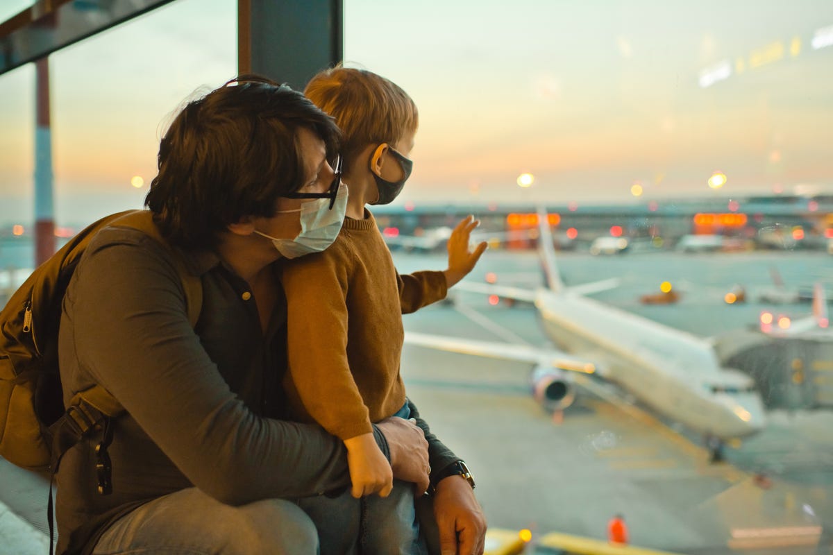 A man and a child look out an airport window