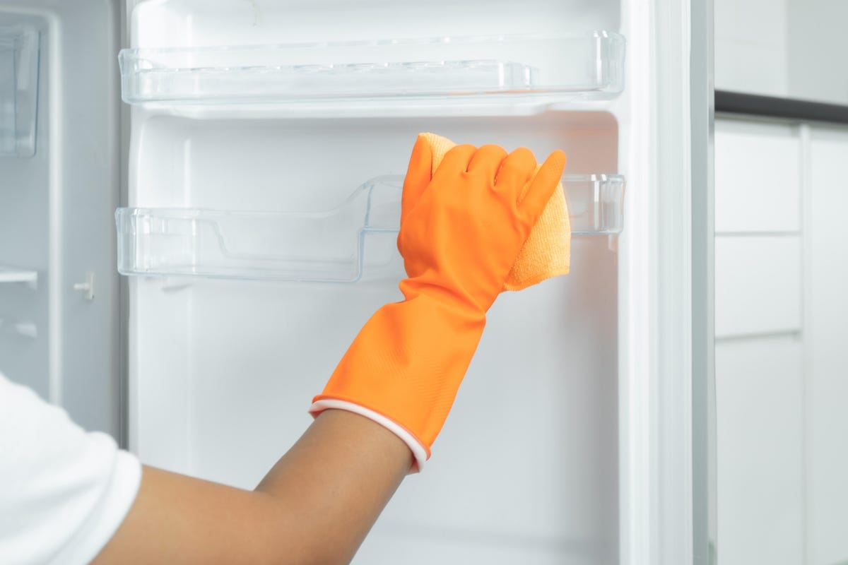 The hand of the woman cleaning the refrigerator was cut off