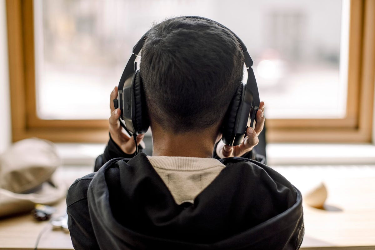 View from behind of a boy wearing headphones.
