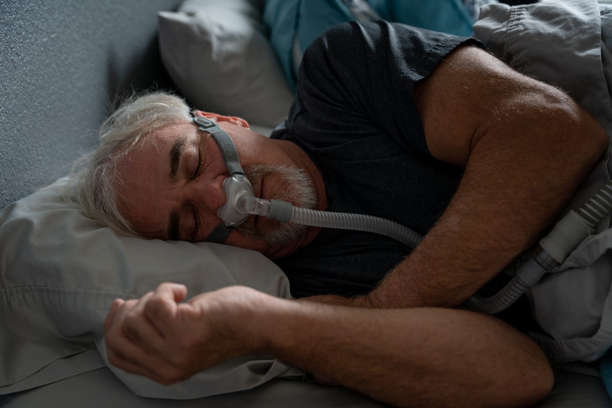 Man sleeping on his side while wearing a CPAP machine
