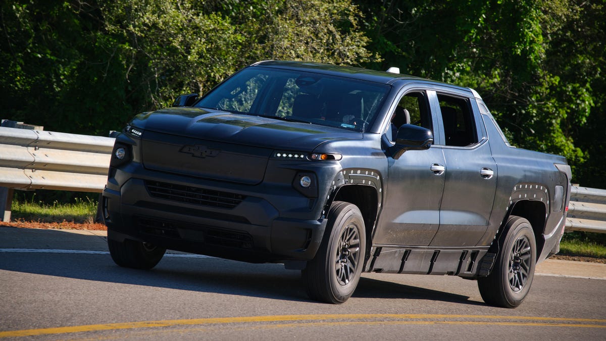 Front 3/4 view of a matte black Chevy Silverado EV prototype on the road