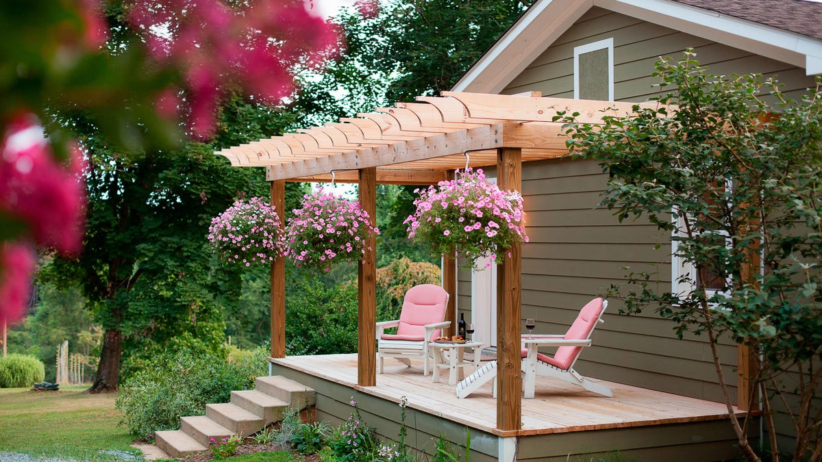 Pink deck chairs and pink flowers in hanging baskets on a veranda