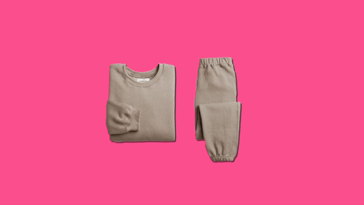 A brown sweatshirt and sweatpants on a pink background
