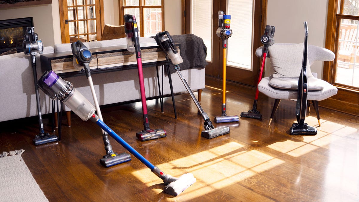A selection of cordless stick vacuums on a hardwood floor