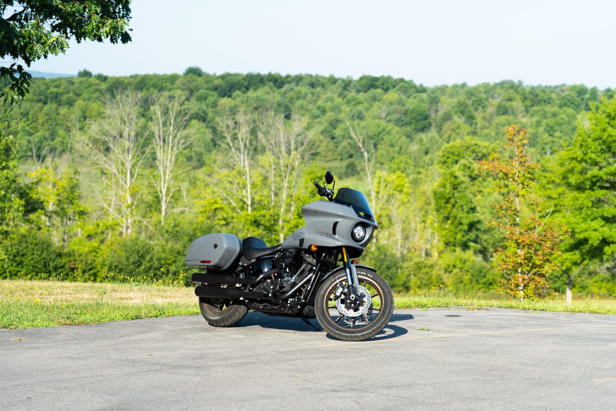 The Harley-Davidson Low Rider ST in gray, long and low with saddle bags on a bright, sunny day.