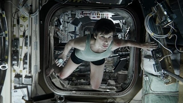 Sandra Bullock as an astronaut floating inside a control room in space