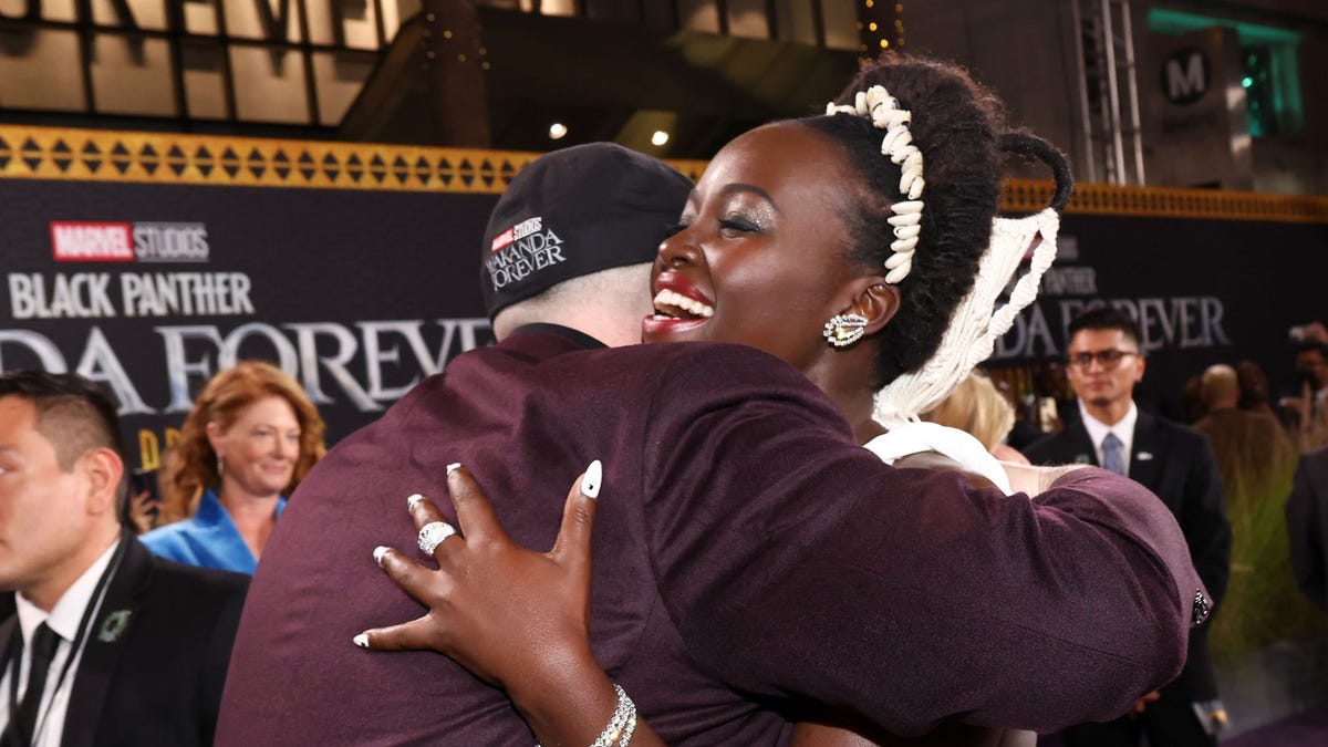 Actor Lupita Nyong'o laughs as she hugs Marvel boss Kevin Feige on the red carpet of the premiere of the movie Black Panther: Wakanda Forever.