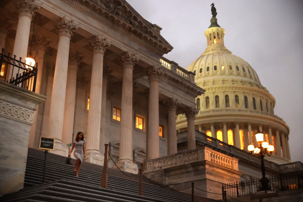 A woman walks down the steps outside the Capitol building.