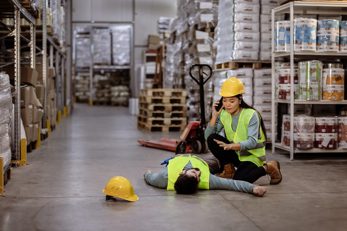 unconscious male worker lying on floor at warehouse
