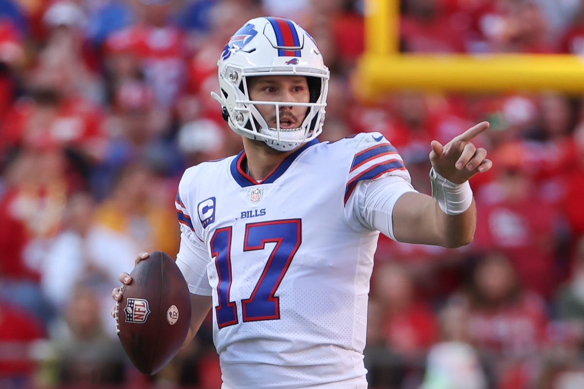 Quarterback Josh Allen of the Bills points while holding a football.