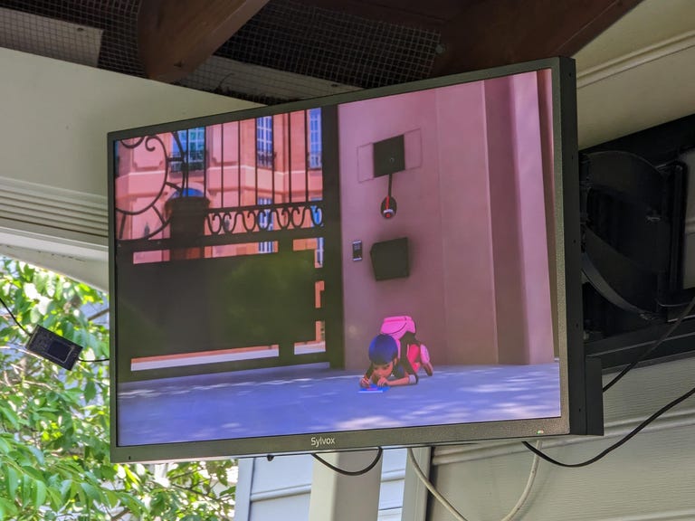 An outdoor TV with Miraculous Ladybug on it