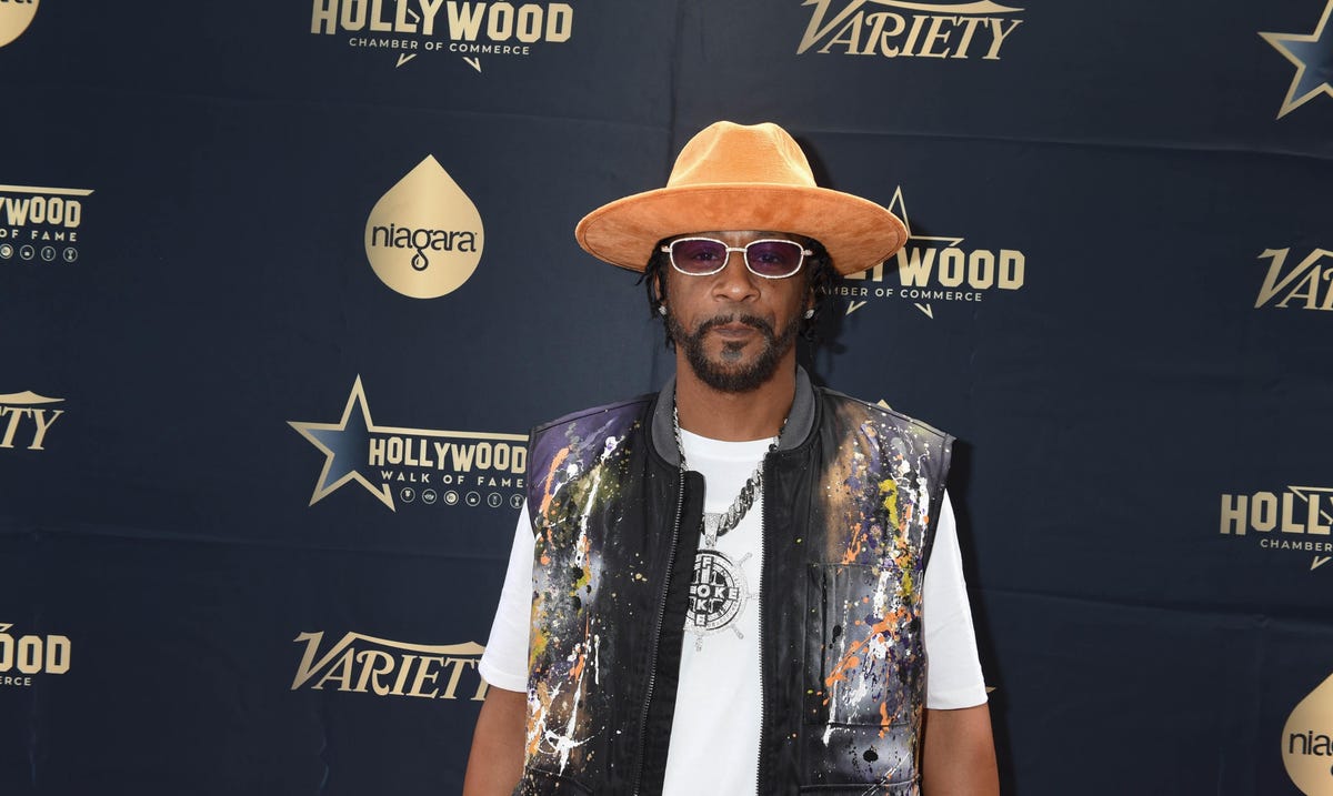 katt williams stands with gold fedora on his head