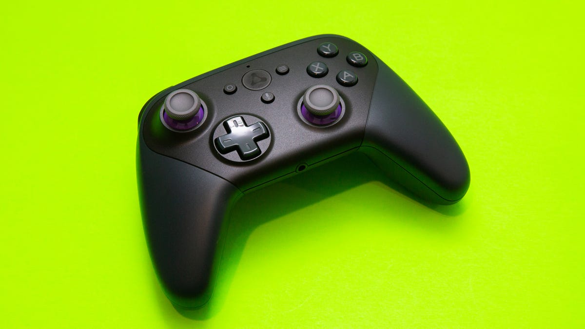 A black Luna gaming controller against a bright green background.