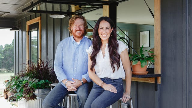 Chip and Joanna Gaines sitting outside of a house