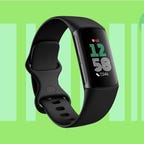 A black Fitbit fitness tracker against a green background.