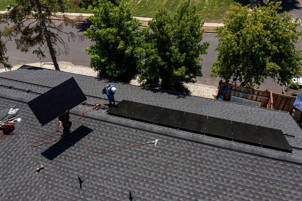 Workers install solar panels on a home in Napa, California, on July 17, 2023.