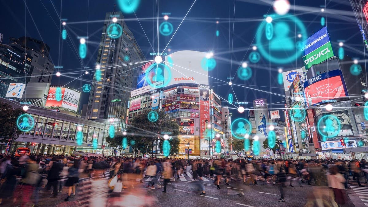 A Tokyo intersection with blurred pedestrians, and above, a network of data notes spread through the city.